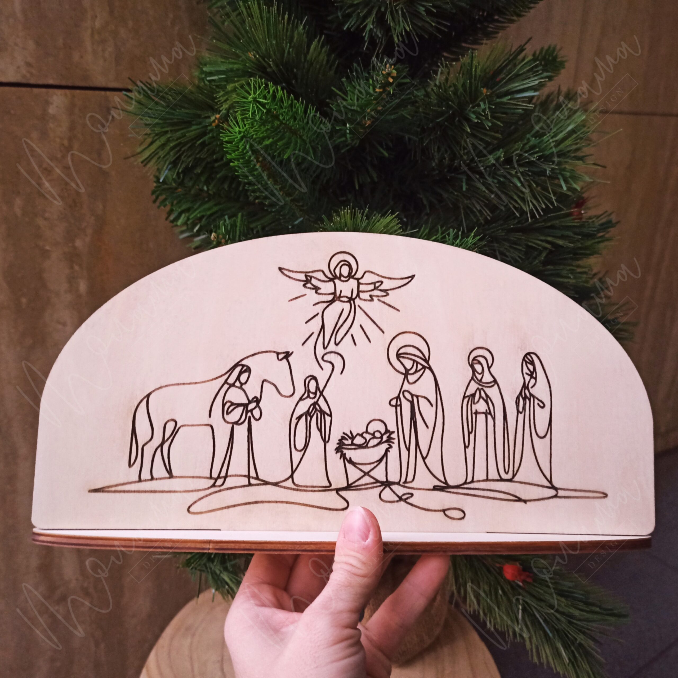 Drevený betlehem – minimalistická dekorácia s gravírovaným motívom narodenia Ježiša v štýle jednej línie, symbol viery a Vianoc.