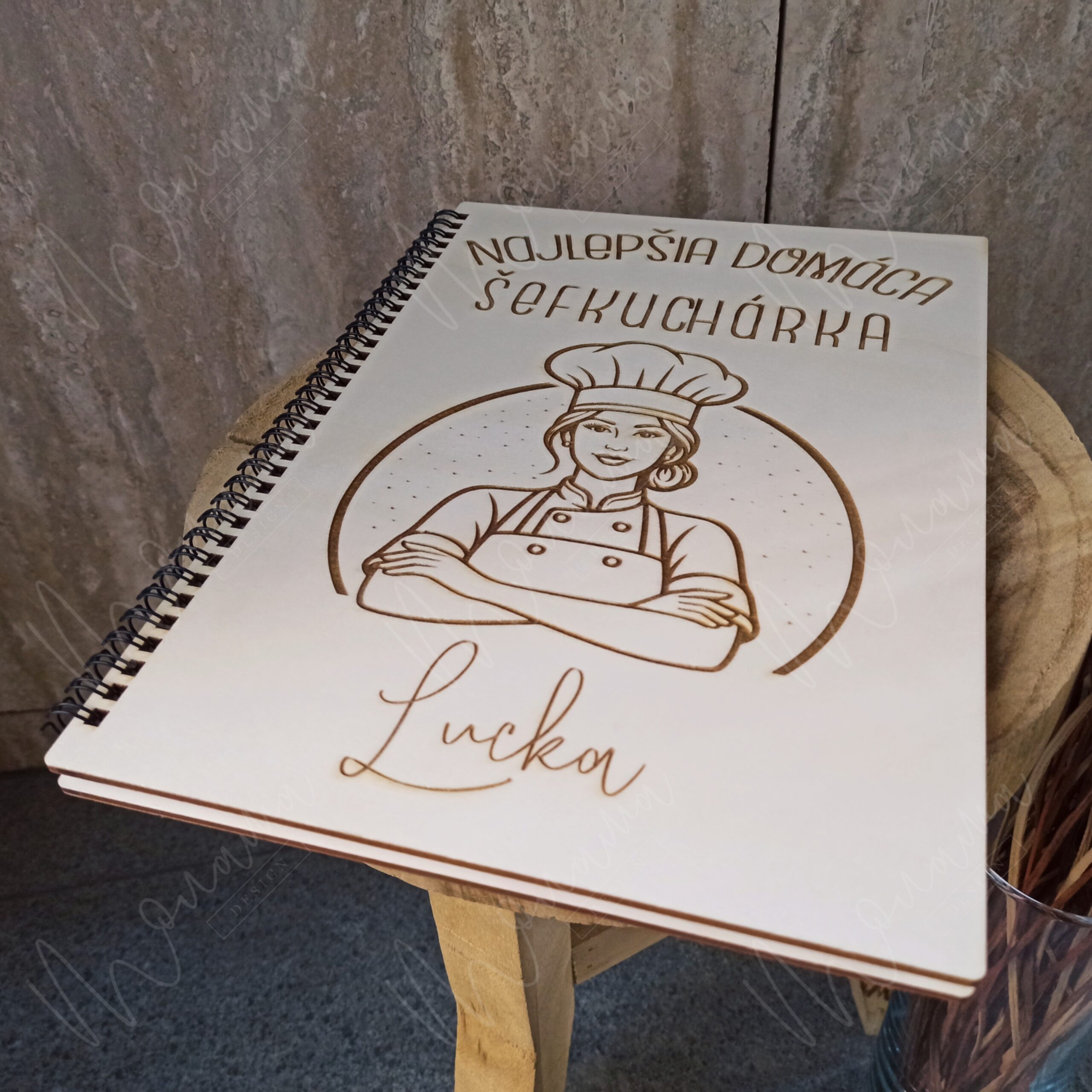 Otvorená drevená kniha receptov (receptár) so špirálovou väzbou a predtlačenými stranami na zapisovanie receptov.