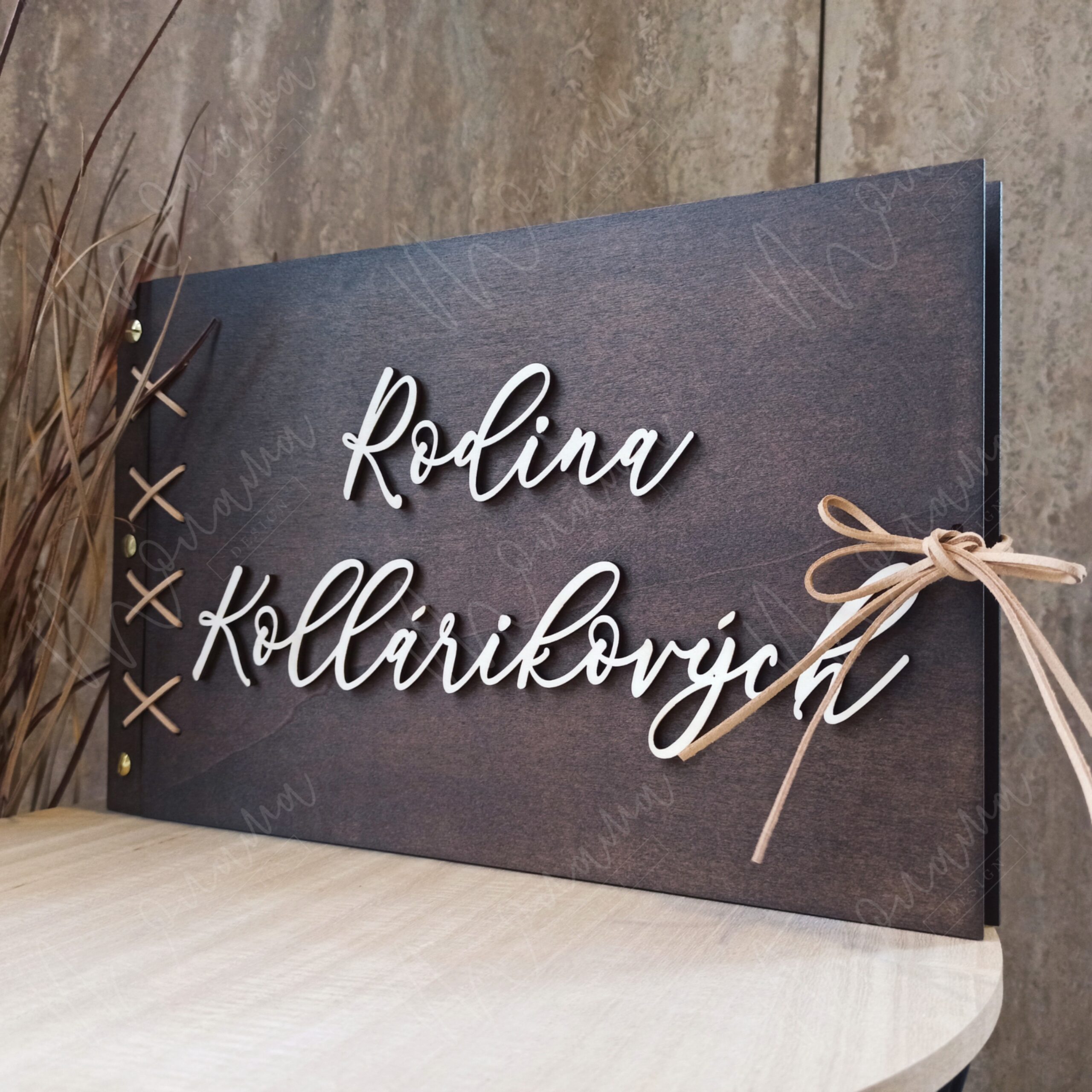 Drevený fotoalbum s personalizovaným 3D nápisom „Rodina Kollárikovych“, tmavé drevo, viazaný stuhou.