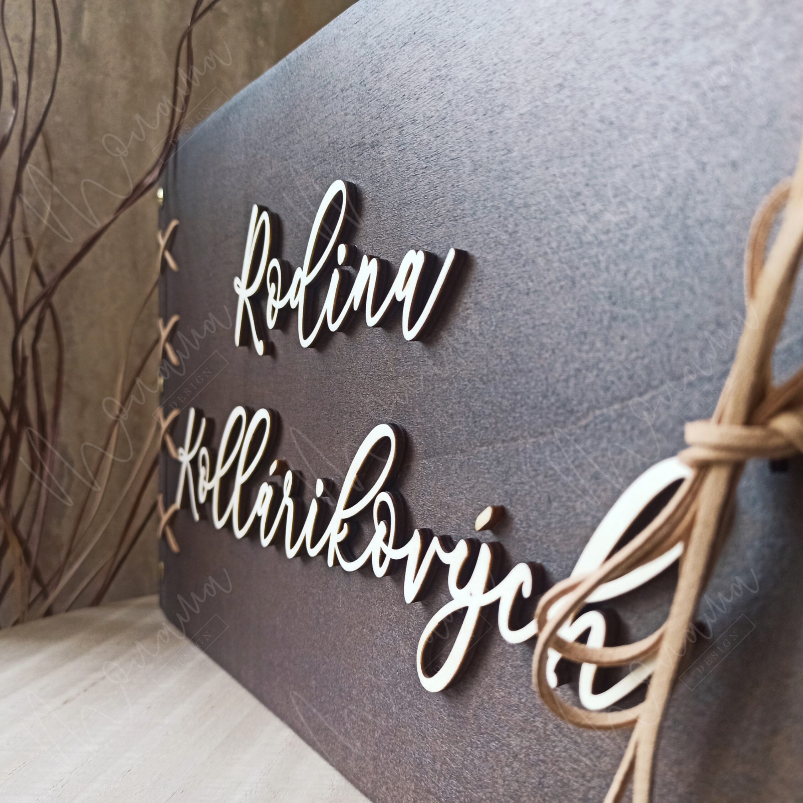 Drevený fotoalbum s personalizovaným 3D nápisom „Rodina Kollárikovych“, tmavé drevo, viazaný stuhou.